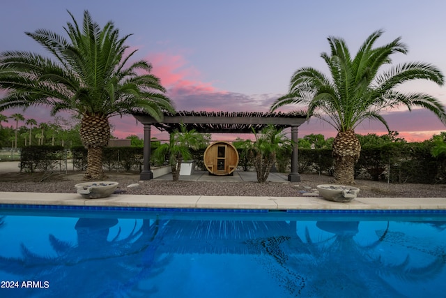 pool at dusk featuring a patio