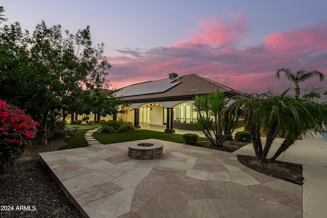 patio terrace at dusk featuring a fire pit