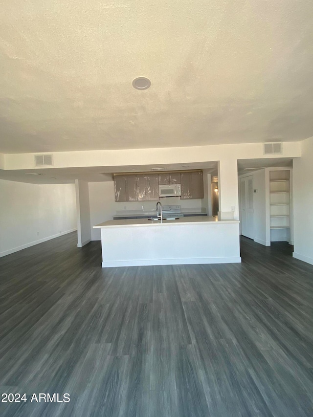 unfurnished living room with a textured ceiling, dark hardwood / wood-style floors, and sink