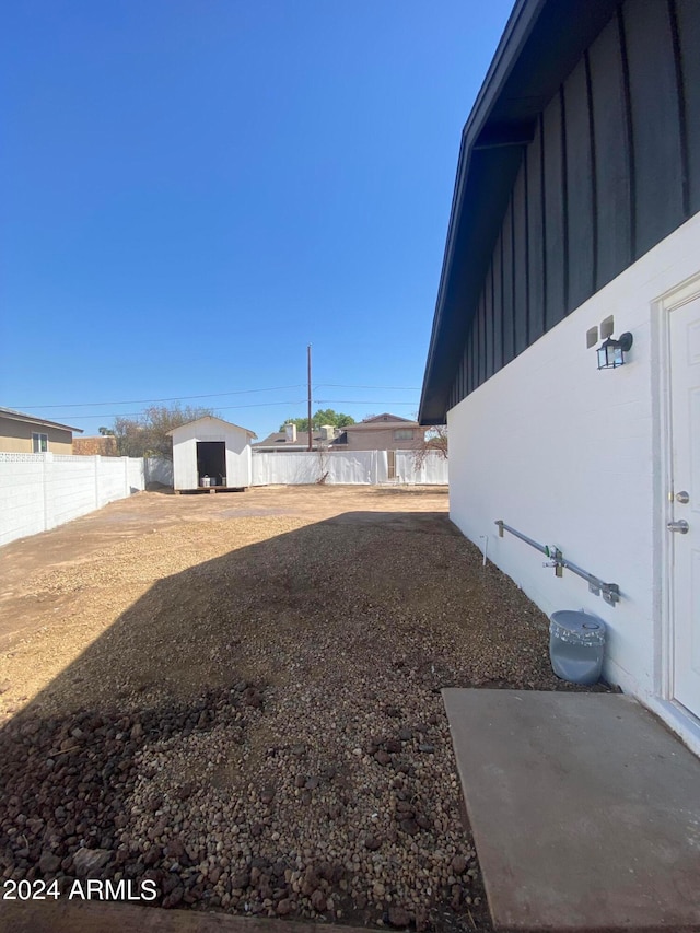 view of yard featuring a shed and a patio area