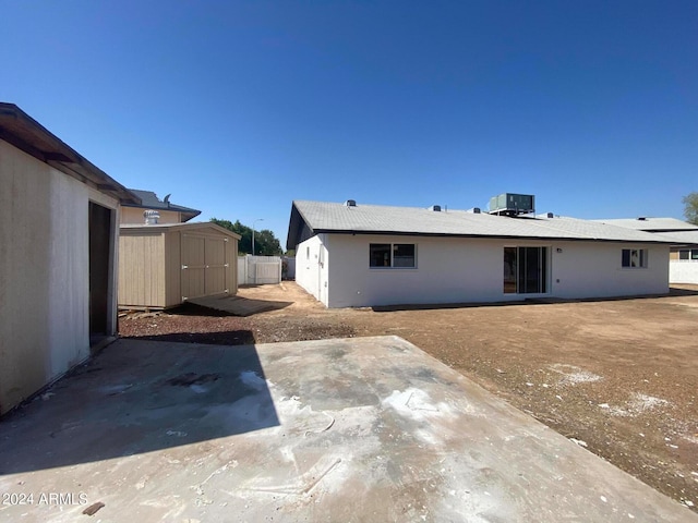 rear view of house featuring a patio, a storage unit, and central AC unit