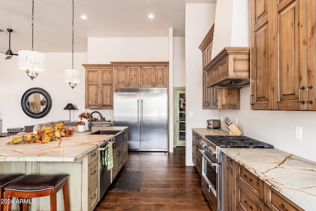 kitchen featuring sink, dark hardwood / wood-style flooring, pendant lighting, a breakfast bar area, and high quality appliances