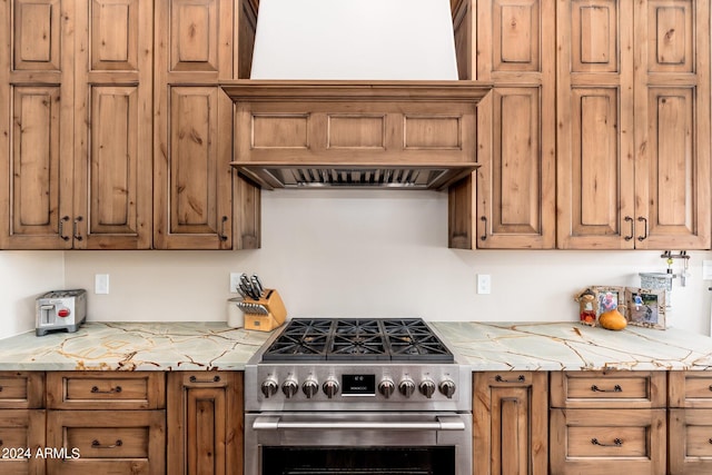 kitchen featuring high end stainless steel range and light stone countertops