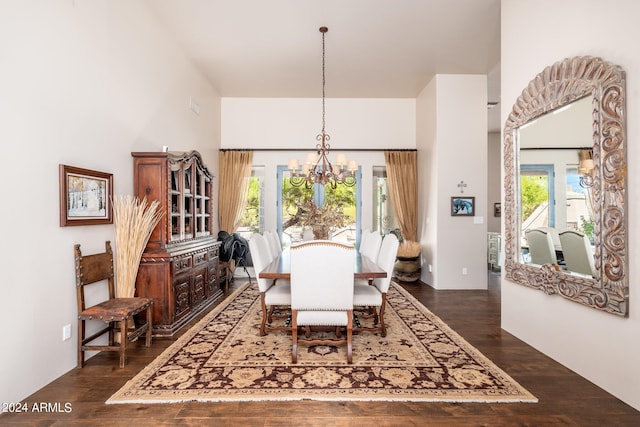 dining space with dark wood-type flooring and a chandelier