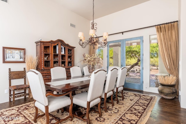 dining area featuring a notable chandelier, dark wood-type flooring, and high vaulted ceiling