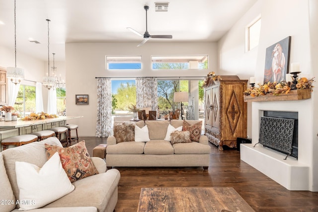 living room featuring ceiling fan with notable chandelier and dark hardwood / wood-style flooring