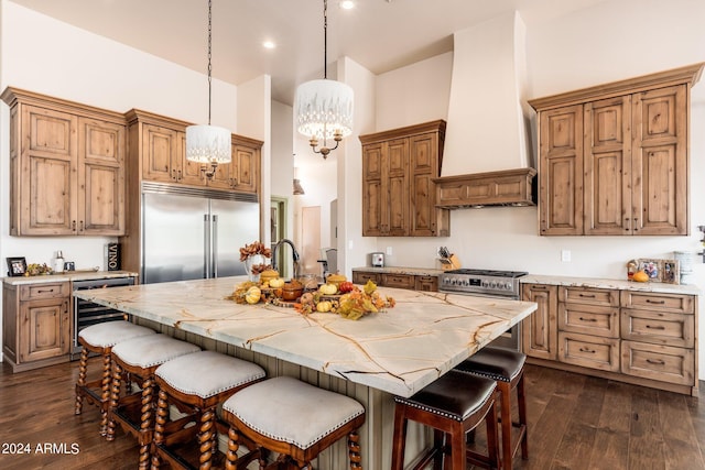 kitchen with stainless steel built in refrigerator, beverage cooler, dark hardwood / wood-style flooring, a center island with sink, and custom exhaust hood