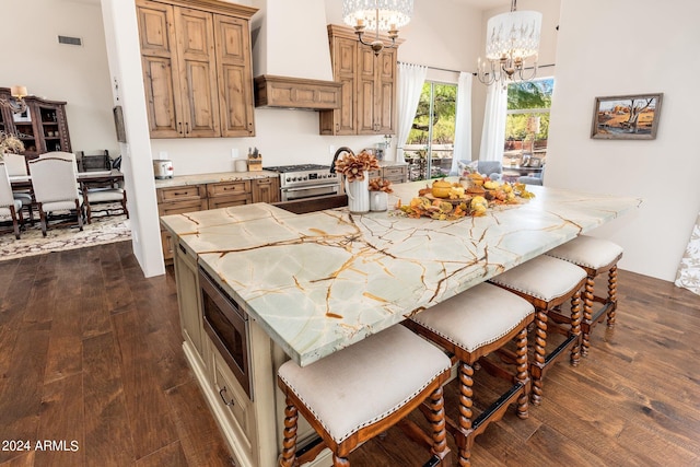 kitchen with custom range hood, dark wood-type flooring, a spacious island, appliances with stainless steel finishes, and decorative light fixtures