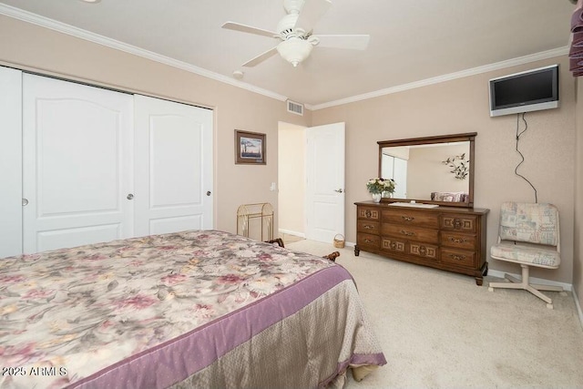 carpeted bedroom featuring a closet, visible vents, and crown molding