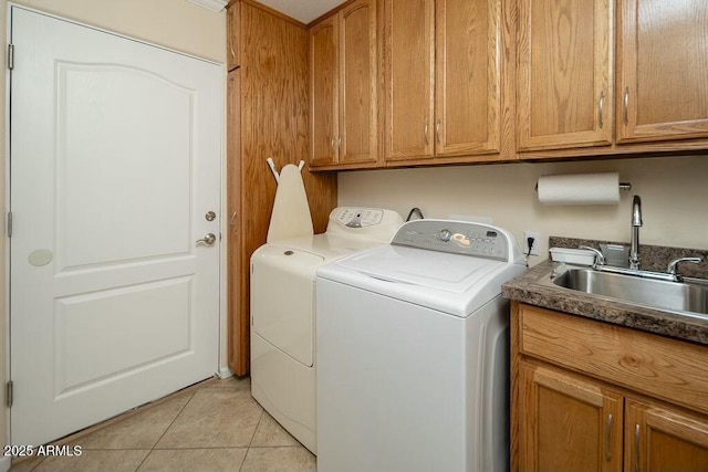 washroom featuring independent washer and dryer, cabinet space, a sink, and light tile patterned floors