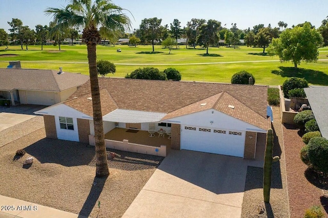 exterior space featuring a garage, view of golf course, a shingled roof, driveway, and a front lawn