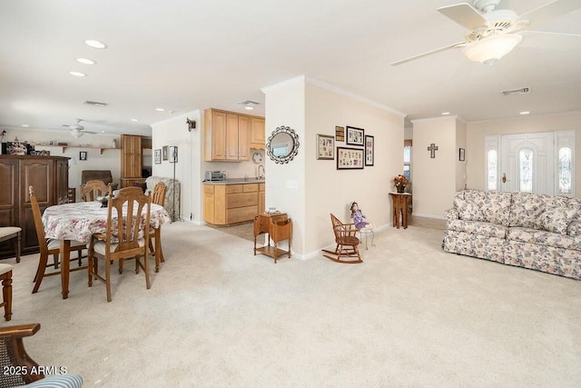 living area with baseboards, visible vents, light colored carpet, ceiling fan, and crown molding