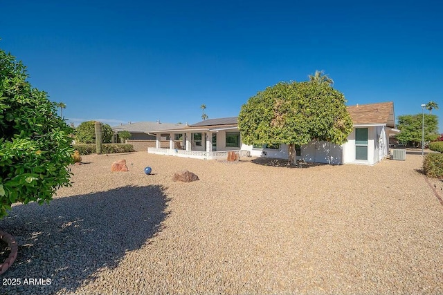 rear view of property with solar panels and central air condition unit