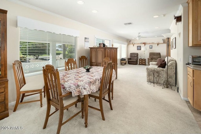 dining area with light carpet, plenty of natural light, visible vents, and crown molding