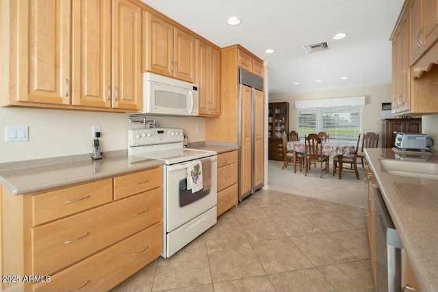 kitchen featuring light tile patterned flooring, recessed lighting, white appliances, a sink, and visible vents