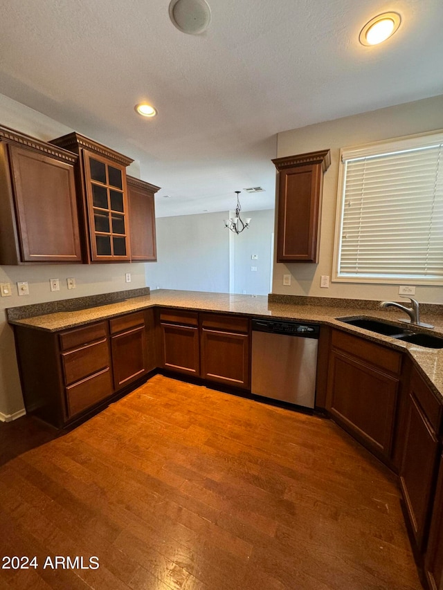 kitchen featuring sink, stainless steel dishwasher, decorative light fixtures, a chandelier, and hardwood / wood-style floors