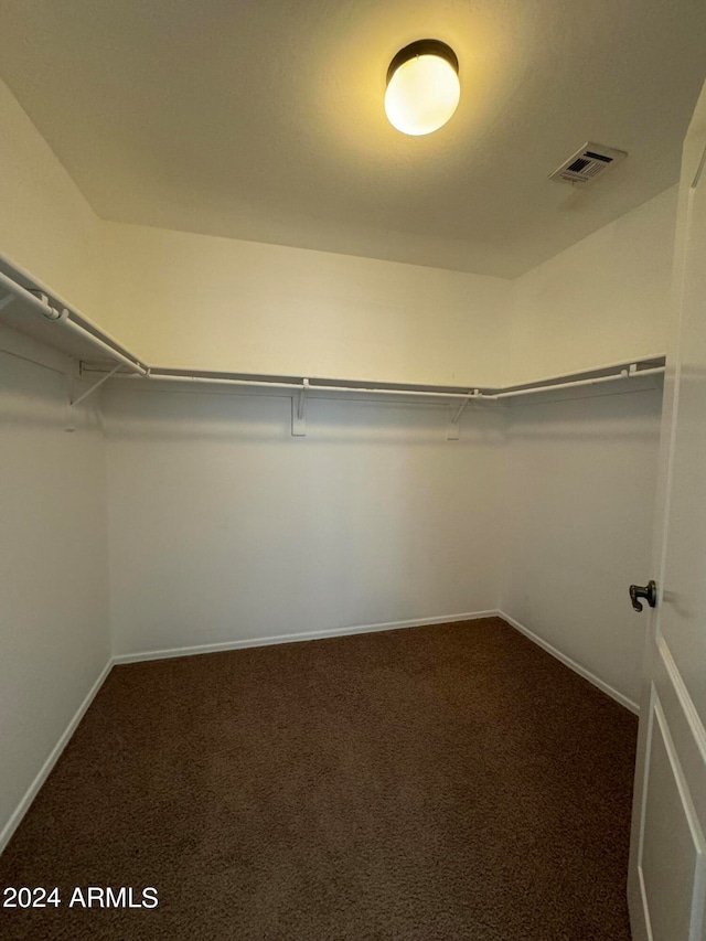 walk in closet featuring dark colored carpet