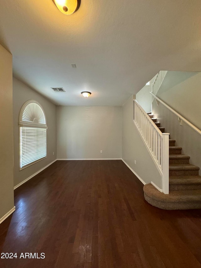 unfurnished living room with dark hardwood / wood-style flooring