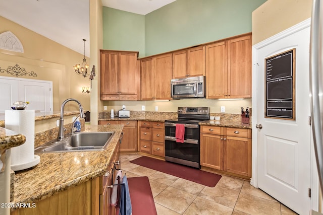 36641 N Railway St, San Tan Valley, AZ 85140 - kitchen featuring light tile patterned floors, brown cabinetry, a sink, stainless steel appliances, and decorative light fixtures
