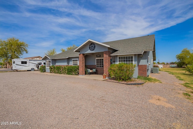 36641 N Railway St, San Tan Valley, AZ 85140 - view of front of house featuring brick siding, a shingled roof, and central air condition unit