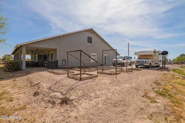 36641 N Railway St, San Tan Valley, AZ 85140 - rear view of property featuring a vegetable garden and stucco siding
