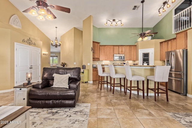 36641 N Railway St, San Tan Valley, AZ 85140 - kitchen featuring ceiling fan with notable chandelier, a kitchen bar, visible vents, stainless steel appliances, and open floor plan