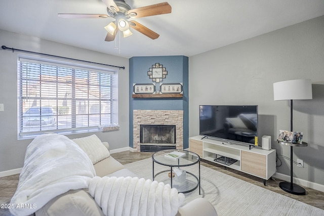 living room with ceiling fan and a fireplace