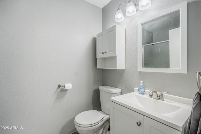 bathroom with vanity, walk in shower, and toilet