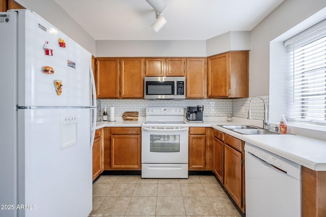 kitchen with light tile patterned flooring, sink, backsplash, and white appliances