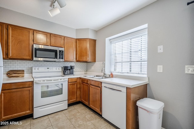 kitchen featuring white appliances, light tile patterned floors, sink, and backsplash