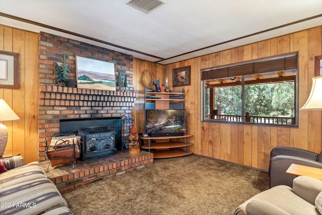 carpeted living room featuring brick wall, wood walls, a wood stove, crown molding, and a brick fireplace