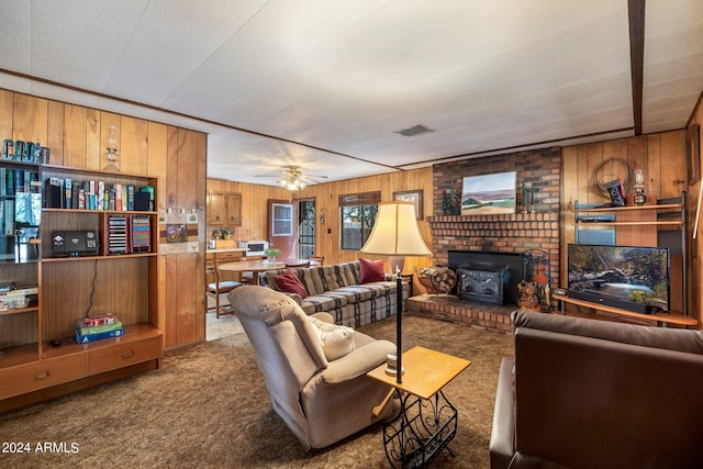 carpeted living room featuring a fireplace, brick wall, wood walls, and ceiling fan