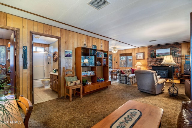 living room featuring wood walls, plenty of natural light, and carpet