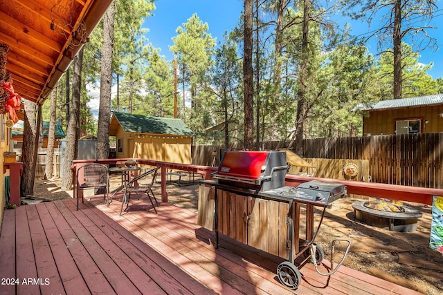 deck featuring an outbuilding and an outdoor fire pit