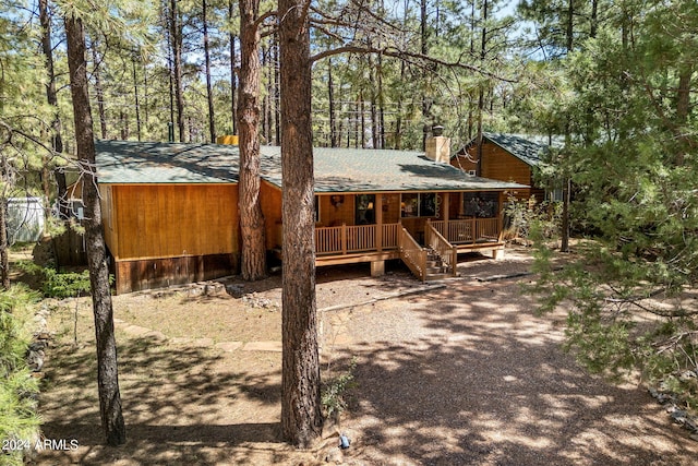 rear view of house featuring a wooden deck