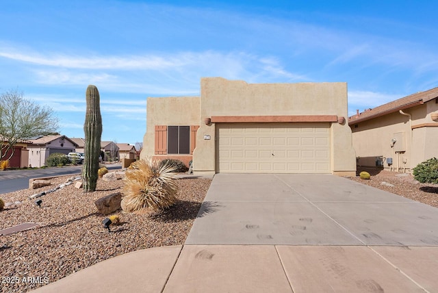 adobe home with a garage, driveway, and stucco siding