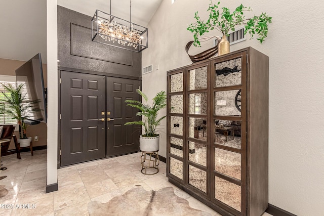 10826 E Navajo Dr, Sun Lakes, AZ 85248 - entryway featuring baseboards, an inviting chandelier, a textured wall, and a towering ceiling