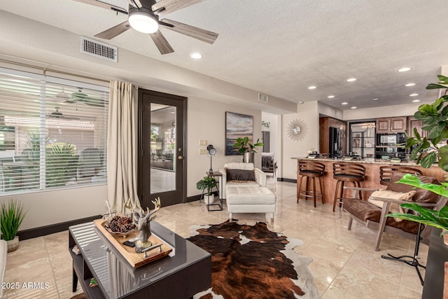 10826 E Navajo Dr, Sun Lakes, AZ 85248 - living room featuring a textured ceiling, visible vents, ceiling fan, and baseboards