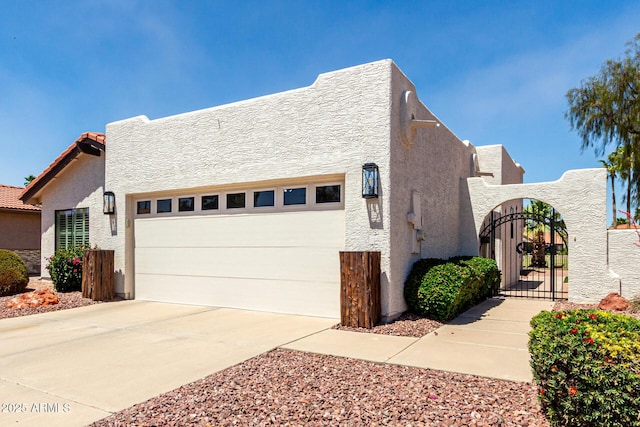 10826 E Navajo Dr, Sun Lakes, AZ 85248 - view of property exterior with stucco siding, a gate, fence, driveway, and an attached garage