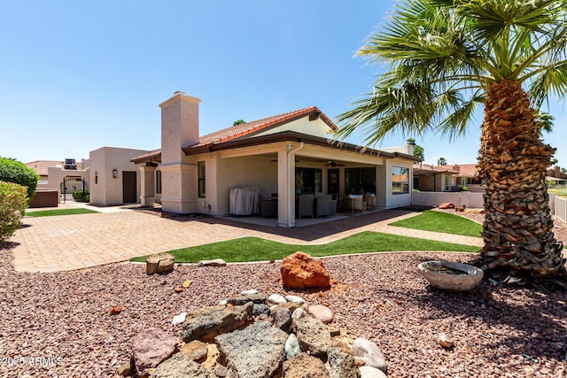 10826 E Navajo Dr, Sun Lakes, AZ 85248 - rear view of house featuring a patio area, a ceiling fan, a chimney, stucco siding, and fence