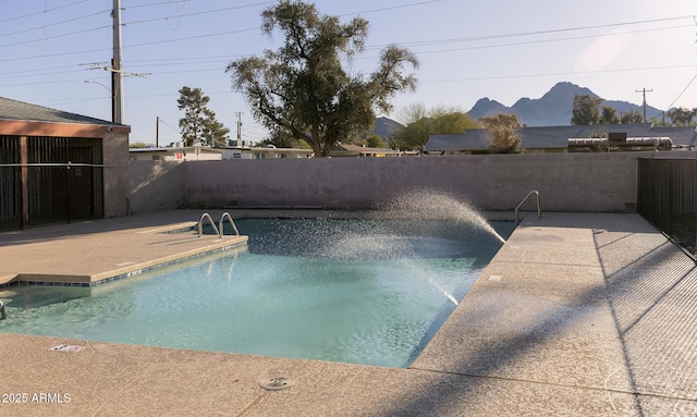 view of pool with a fenced in pool, a fenced backyard, a mountain view, and a patio area