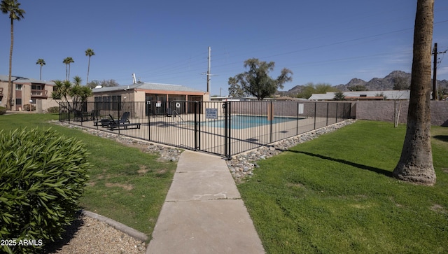 community pool with a patio area, a yard, and fence