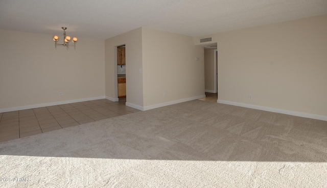 unfurnished room featuring visible vents, light carpet, a notable chandelier, light tile patterned floors, and baseboards