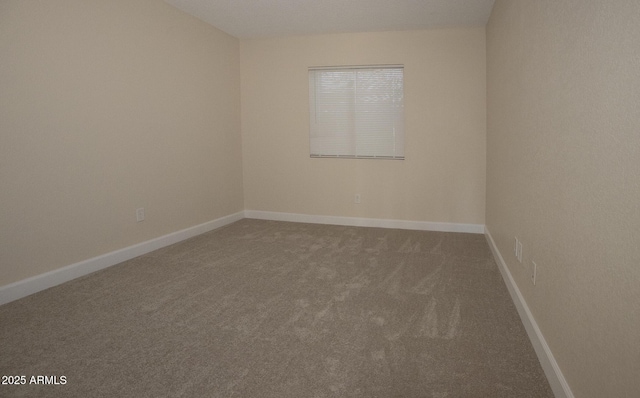 carpeted empty room with baseboards