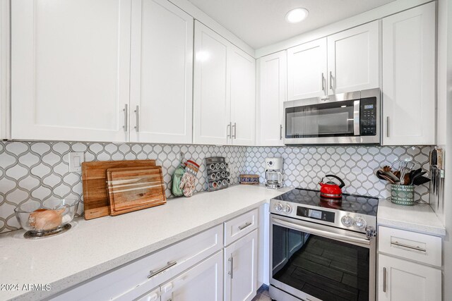 kitchen featuring appliances with stainless steel finishes, tasteful backsplash, and white cabinets