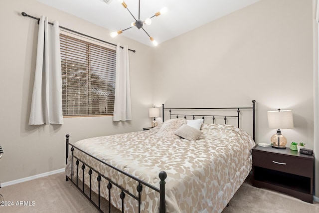 bedroom with a chandelier and light colored carpet