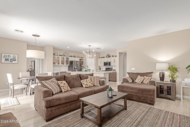 living room featuring a chandelier and light hardwood / wood-style floors