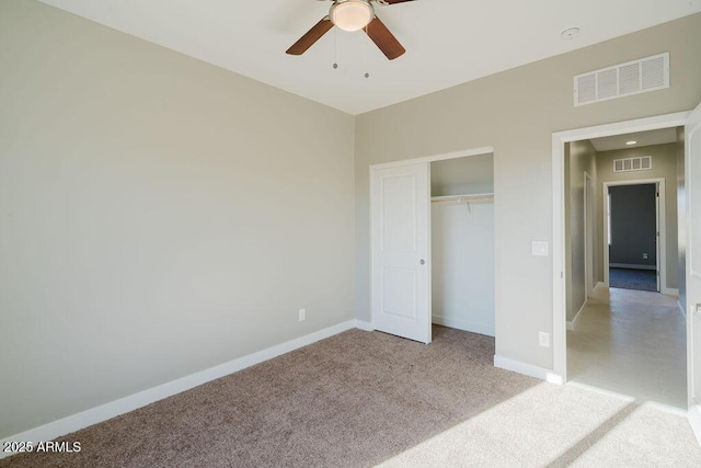 unfurnished bedroom featuring ceiling fan, a closet, and light carpet