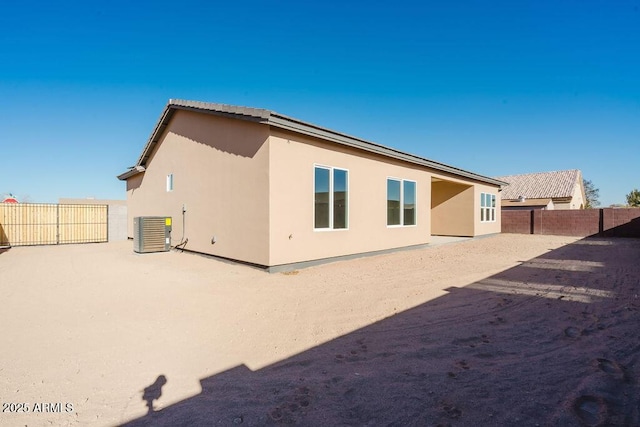 rear view of house with a patio area and cooling unit