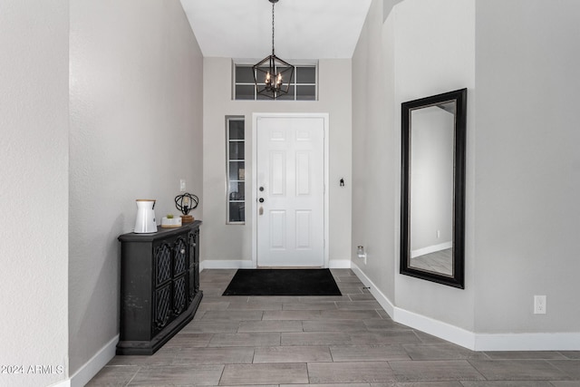 entrance foyer featuring a towering ceiling, a chandelier, and hardwood / wood-style flooring